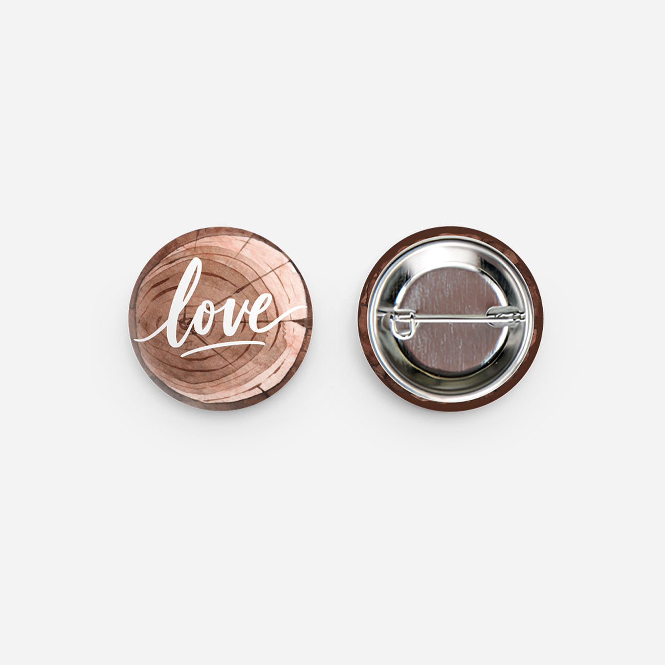 Pinback metal button that says 'love' on a wood tree design.